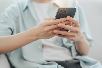 Close up view of young college girl using smartphone while sitting in simple workplace