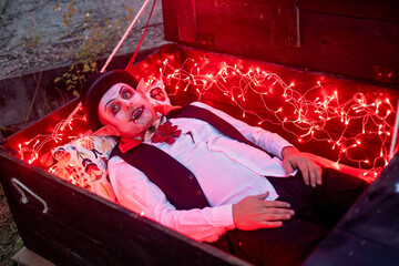 Children, celebrating Halloween outdoors at night, dracula, vampire, mumie, pumpkins