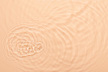 Fototapeta na wymiar Water beige surface abstract background. Waves and ripples texture of cosmetic aqua moisturizer with bubbles.