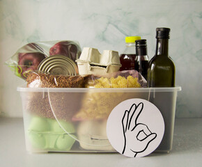 Plastic box with set of products. Charitable assistance and food delivery to those in need during...