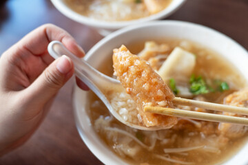 Delicious fried narrow-barred Spanish mackerel fish fillet with rice and noodles in thick soup in...