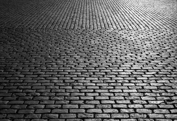 Old cobblestones on Market place “Grote Markt“ in Antwerp Belgium. Shiny historic basalt ashlars and blocks reflecting sunshine. Pavement background, black and white greyscale with high contrast. - obrazy, fototapety, plakaty