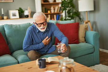 A senior man suffering from chest pain or heart attack at home