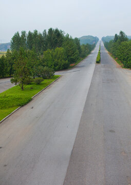 North Korean man riding a bicycle on an empty highway, North Hwanghae Province, Kaesong, North Korea