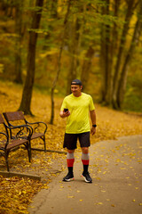 Obraz premium Portrait of a middle-aged man running in the park on an autumn day.