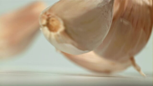 Fresh garlic falls on the table. Filmed on a high-speed camera at 1000 fps. High quality FullHD footage