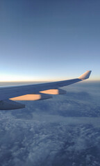 Obraz premium fly and travel, view from the window of an airplane on the wing during sunset