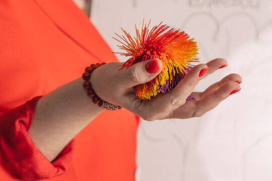 Silicone ball in a woman's palm. A special ball used in various developmental training, therapy and restoration of fine motor skills.