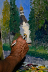 The hand of an elderly artist at the time of painting.