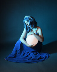 Full length portrait of beautiful female model wit blue hair wearing glamorous  fantasy ball gown...
