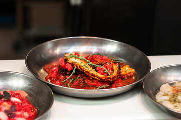 Cooked octopus tentacle in berry sauce, seafood food in fast food or street food.