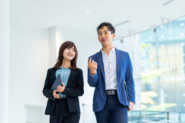 オフィスを歩くビジネスマン男女