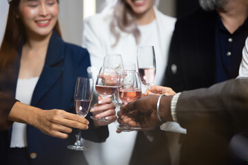 Closeup hand holding glassware. Business people celebrate making a toast on event party at office. Celebration Success Concept