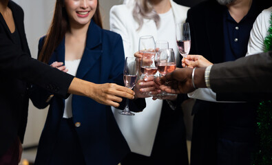 Closeup hand holding glassware. Business people celebrate making a toast on event party at office. Celebration Success Concept