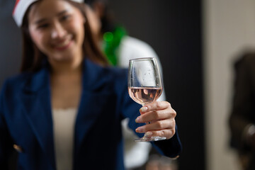 Closeup asian thai woman hand holding glassware. Business people celebrate making a toast on event party at office. Celebration Success Concept