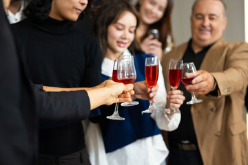 Closeup hand holding glassware. Business people celebrate making a toast on event party at office. Celebration Success Concept