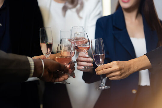 Closeup hand holding glassware. Business people celebrate making a toast on event party at office. Celebration Success Concept