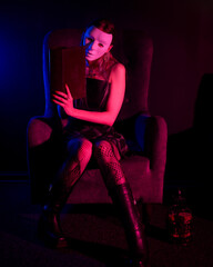 An enigmatic female figure bathed in vivid neon light poses dramatically, her face masked, evoking themes of mystery, nightlife, and modern cyberpunk aesthetics.