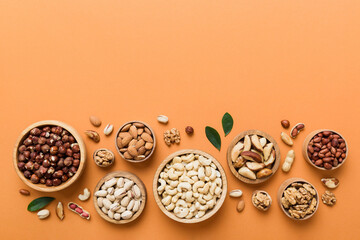 mixed nuts in wooden bowl. Mix of various nuts on colored background. pistachios, cashews, walnuts, hazelnuts, peanuts and brazil nuts