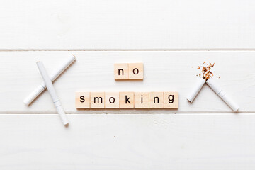 Cigarette And Wooden Blocks, Broken cigarette on table background, No Tobacco Day with hourglass, clock health concept. time to quit smoking