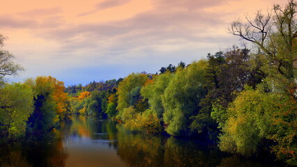 idyllischer, natürlicher Neckar bei Rottenburg im rosa Abendlicht im Herbst mit grünen Bäumen