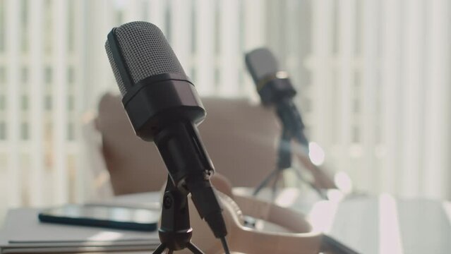 Selective focus on microphones on table of blogger with headphones and other equipment