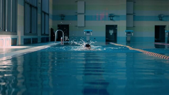 Swimmer with mask trains butterfly style in swimpool