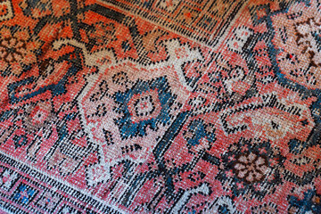 Old oriental woolen carpet with traditional colorful floral ornament