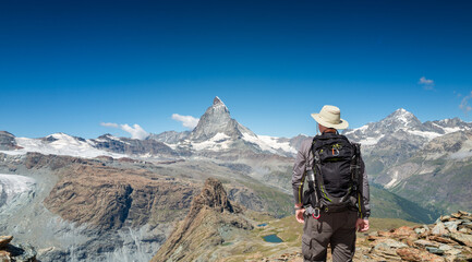 Switzerland Travel -  senior man hiking Switzerland near Matterhorn