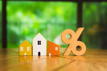 Percentage and house sign symbol icon wooden on wood table. Concepts of home interest, real estate, investing in inflation home loan interest rate hike. - obrazy, fototapety, plakaty