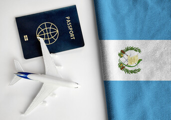 Flag of Guatemala with passport and toy airplane. Flight travel concept 