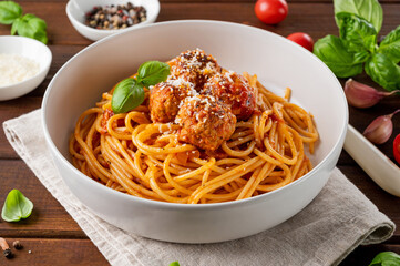 Traditional Italian spaghetti pasta with meatballs, tomato sauce and parmesan cheese, selective focus. Comfort food.