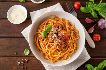 Traditional Italian spaghetti pasta with meatballs, tomato sauce and parmesan cheese, selective focus. Comfort food.