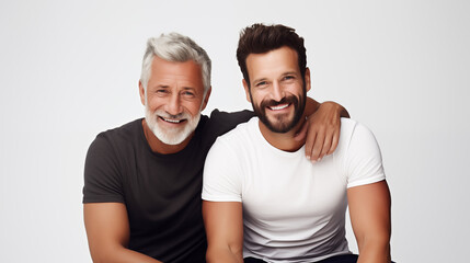 Le portrait d'un père et son fils souriants et heureux sur un fond coloré uni