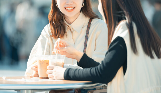 テラス席でコーヒーを飲む2人の若い日本人女性