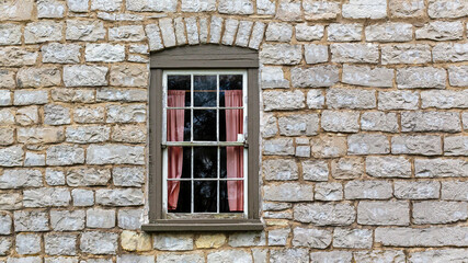 Fototapeta na wymiar vintage stone brick wall with an antique window exterior building background texture