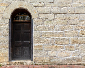 Fototapeta na wymiar vintage stone brick wall with an antique door exterior building background texture