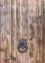 .Part of a large wooden door with an iron handle and ring. Spain