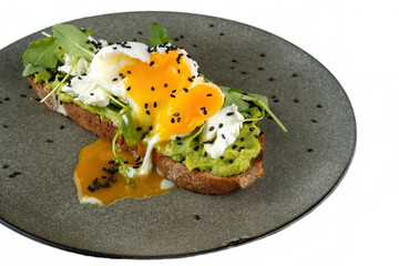 Avocado toast with poached egg on a wooden board. Breakfast concept.