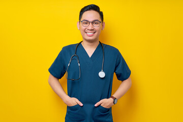 Handsome young Asian man doctor or nurse wearing a blue uniform and glasses confident looking at...
