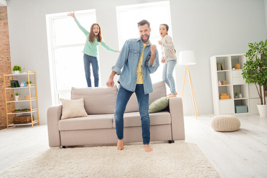 Full size photo of three people delighted man fist up open mouth success positive girl standing on couch indoors