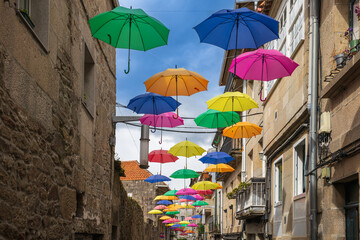 Fototapeta na wymiar Multicolored ornamental umbrellas on a street in the city of Pontevedra, in Galicia.Spain