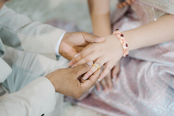 Hands of bride and groom on wedding day. Wedding concept.Thai wedding ring wearing ceremony
