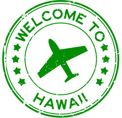 Grunge green welcome to word hawaii with plane icon round rubber seal stamp on white background