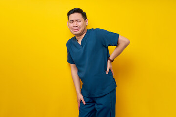 Professional young Asian male doctor or nurse wearing a blue uniform feeling sick and suffering...