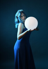 Close up portrait of beautiful female model with blue hair wearing glamorous  fantasy ball gown,...