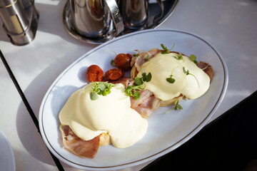 Eggs Benedict common American breakfast or brunch dish, consisting of two halves of an English...