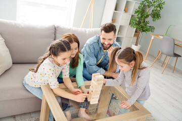 Portrait of attractive cheerful funny family playing building pile stack pyramid free time at home...