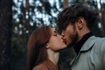 Naklejka premium sensual couple in love close-up kissing, curly man and beautiful woman.
