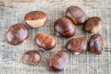 close up raw chestnuts on wooden table
